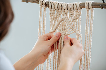 Hands tying a macram&eacute; knot